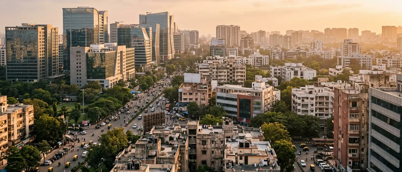 Golden-hour skyline of a modern Indian city — glass office towers rising over dense low-rise neighbourhoods threaded with greenery